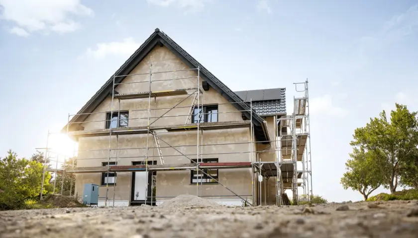 Maison en construction avec échafaudages. Le chantier laisse imaginer le futur prix de rénovation maison.