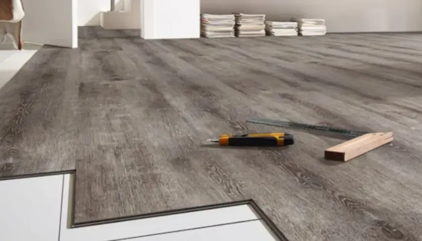 Installazione pavimenti LVT: un taglierino e una squadra pronti per correggere eventuali difetti.