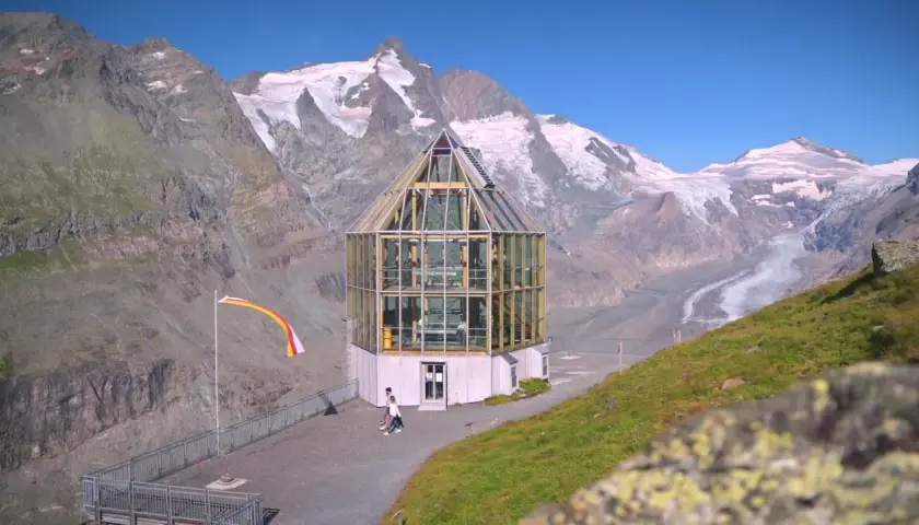 Szklana budowla na tle najwyższego szczytu Austrii, Grossglockner. Lodowiec w oddali.