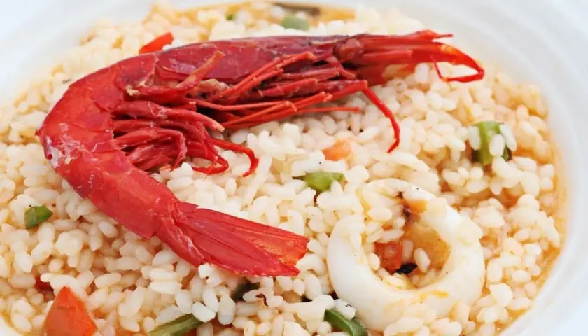 Delicioso arroz con carabineros, calamares y verduras. Un plato que huele a mar y sabe a tradición.