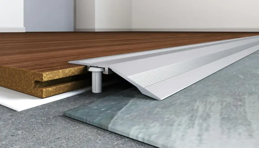 Profilo metallico per accostare pavimenti diversi, come legno e pietra, garantendo una transizione fluida e sicura.