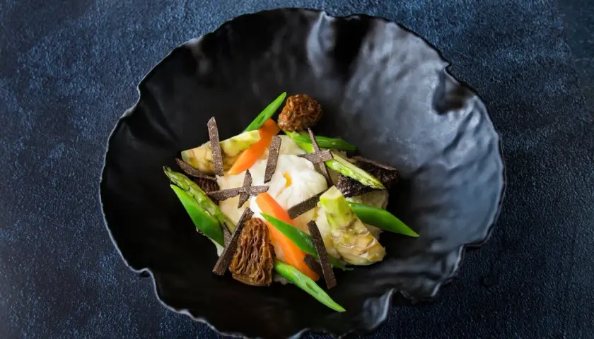 Parmentier de patata con espárragos, zanahorias, morillas y láminas de trufa negra.