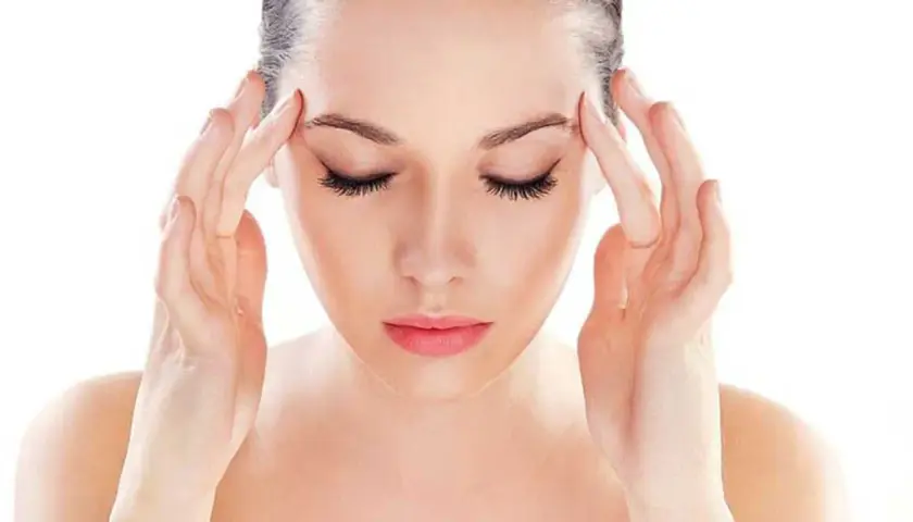 Donna con le mani sulle tempie, soffre di mal di testa da stress. Scopri come farlo passare con rimedi naturali.