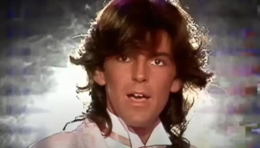 Thomas Anders z burzą włosów i w jasnej koszuli z krawatem.