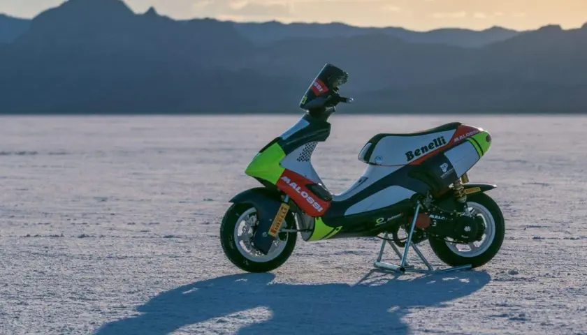 Scooter de carreras Benelli con gráficos Malossi en un paisaje desértico. ¿Cuántos caballos tiene una 49?