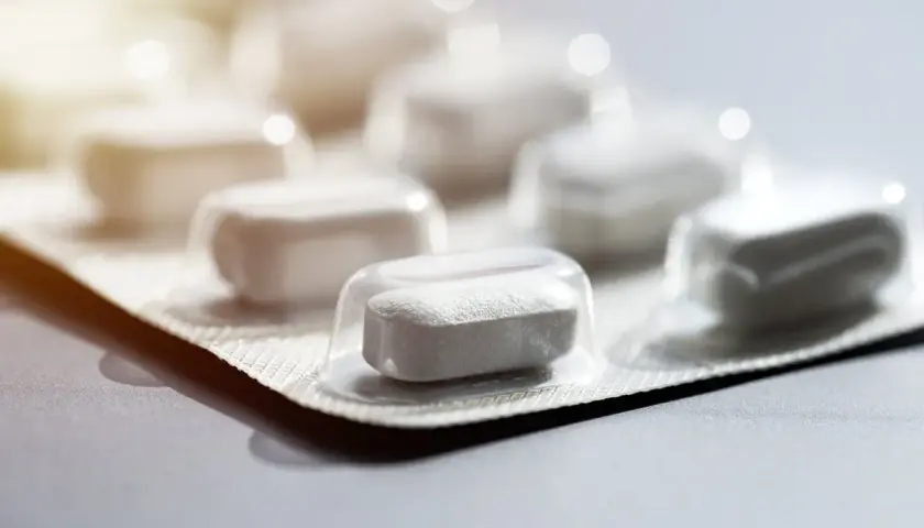 Un blister de comprimés blancs, rappelant l'azithromycine. Il est conseillé d'éviter l'alcool lors de la prise de ce traitement.
