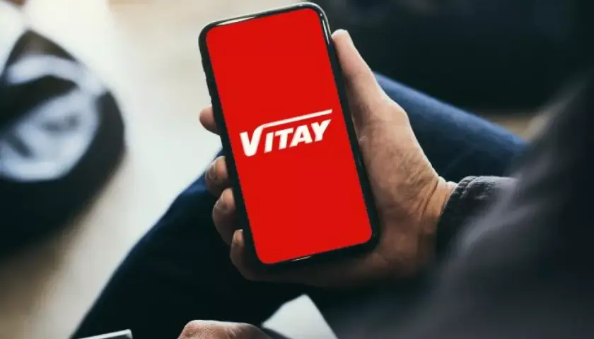 Dłoń trzyma smartfon z czerwoną kartą VITAY.