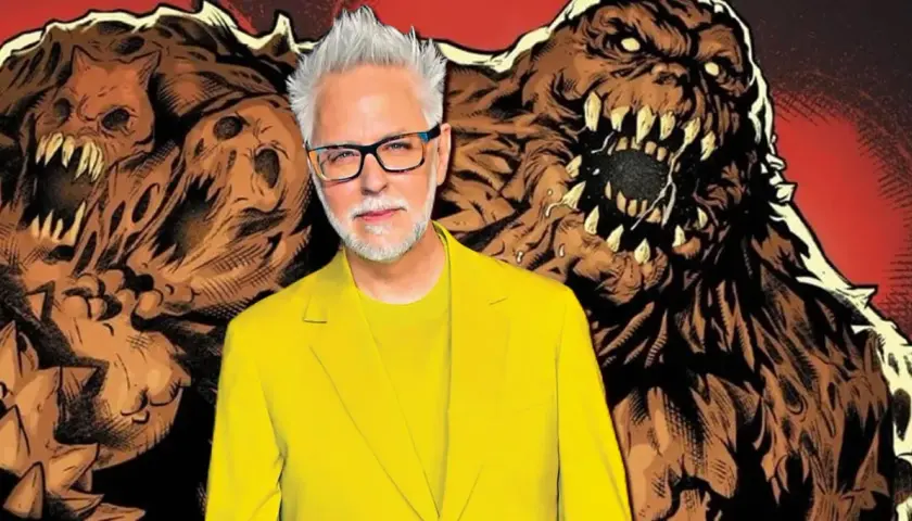 James Gunn, en costume jaune vif, pose devant des créatures monstrueuses en terre, évoquant un futur film Swamp Thing.