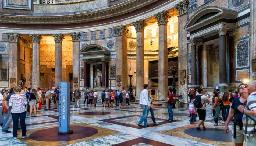 Interno del Pantheon a Roma, con turisti che ammirano la maestosa architettura e le colonne. La Piazza della Rotonda è un luogo iconico.