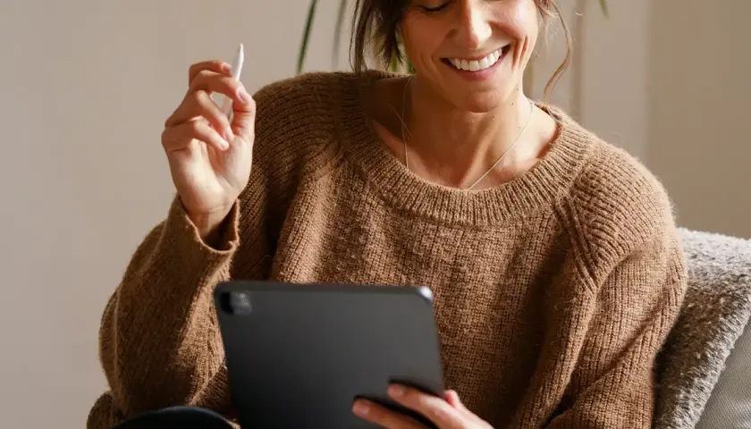 Uśmiechnięta kobieta z rysikiem w dłoni przegląda coś na tablecie. Jaki tablet, taki komfort pracy!