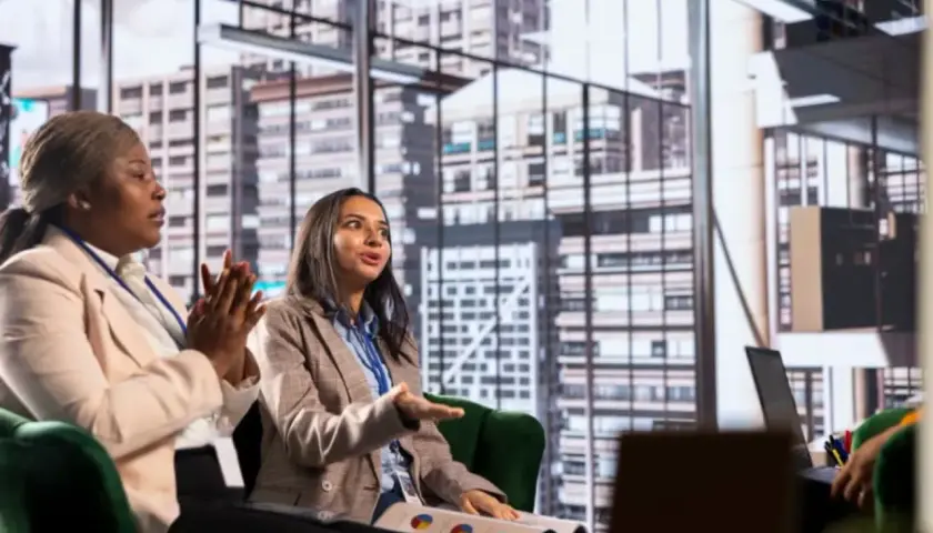 Two women in a meeting discuss business strategy, perhaps inspired by their organizational management degree.