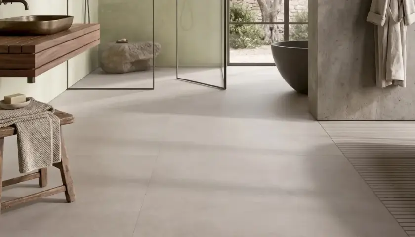 Bagno moderno con gres porcellanato effetto cemento. Pro: stile minimal, facile da pulire. Contro: può risultare freddo al tatto.