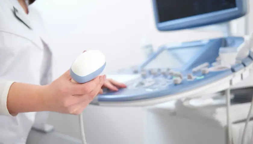 Lekarz trzyma sondę aparatu USG, przygotowując się do badania echo serca. Prawidłowe parametry echo serca są kluczowe dla diagnozy.
