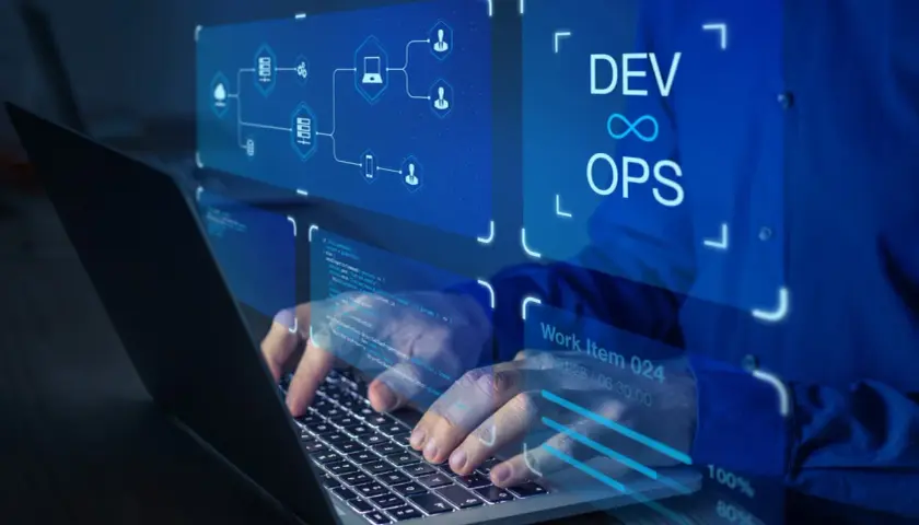 Ręce programisty pracującego na laptopie, wizualizacja zastosowania chmury obliczeniowej i DevOps.