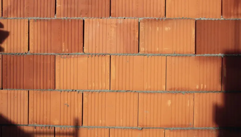 Ściana z cegieł POROTHERM w zbliżeniu. Widoczne poziome spoiny zaprawy i pionowe kanaliki w cegłach.