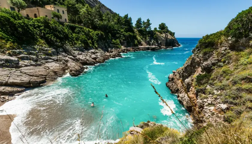 Baignade dans les eaux turquoise d'une crique isolée, un rêve de vacances sur la côte amalfitaine.