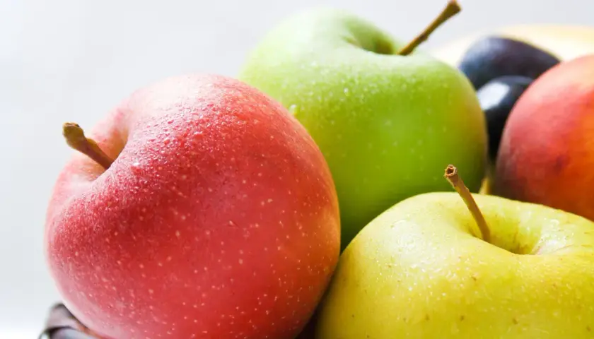 Frische Äpfel in Rot, Grün und Gelb, mit Wassertropfen bedeckt. Sie sind ein gesunder Snack und bieten gute Apfel Nährwerte.