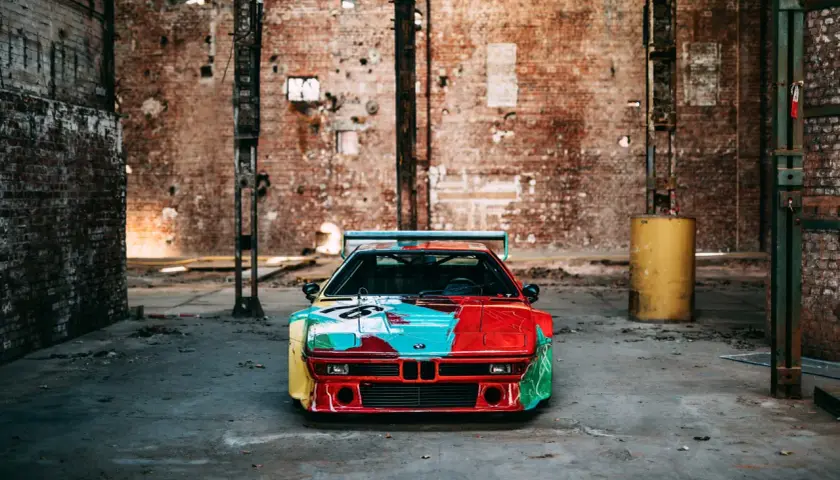 Kultowe BMW M1 w artystycznym malowaniu, stojące w opuszczonej fabryce.