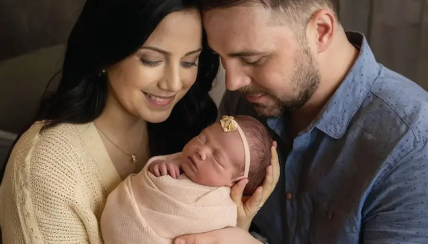 Ciepłe sesje noworodkowe z rodzicami. Mama i tata z czułością tulą swoje maleństwo, tworząc niezapomniane wspomnienia.