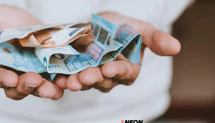 Hände halten Euro-Scheine. So können Sie Ihre **monatlichen Kosten senken** und mehr Geld sparen.