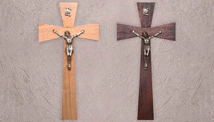 Dwa drewniane krzyże z figurkami Jezusa. Jeden jasny, drugi ciemny. Symbol wiary, jak tatuaż krzyż na palcu znaczenie.