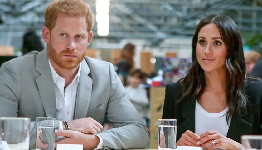 Meghan i Harry siedzą przy stole, rozmawiając.