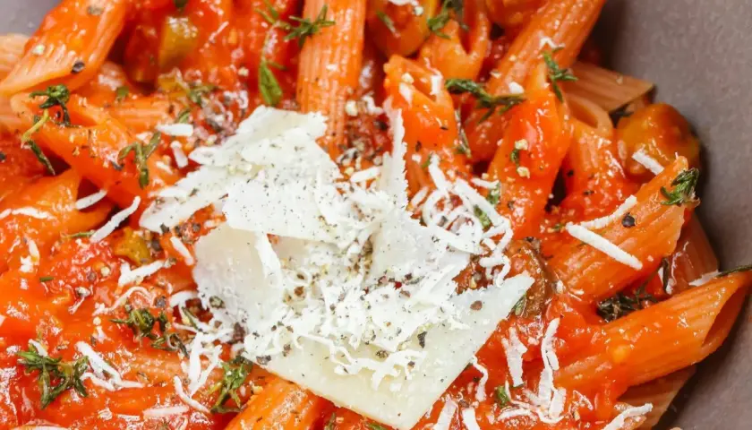 Penne z sosem pomidorowym, oliwkami i parmezanem. Idealny tani szybki obiad, który zadowoli każdego.