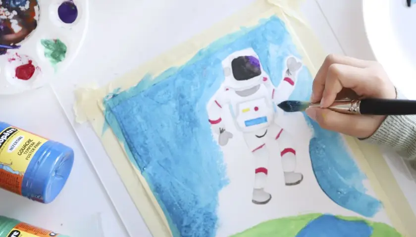 Niño pintando un astronauta en el espacio. Un proyecto de arte en infantil que fomenta la creatividad y la imaginación.
