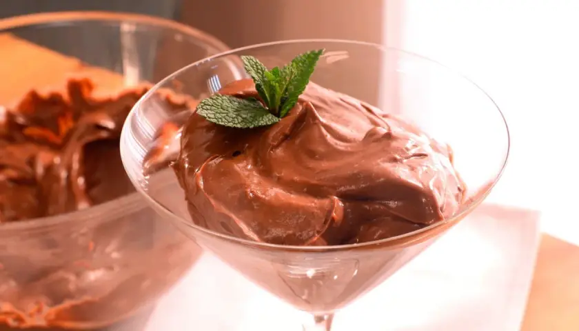 Deliciosa crema de cacao pralin, servida en copa de cóctel y decorada con menta fresca.