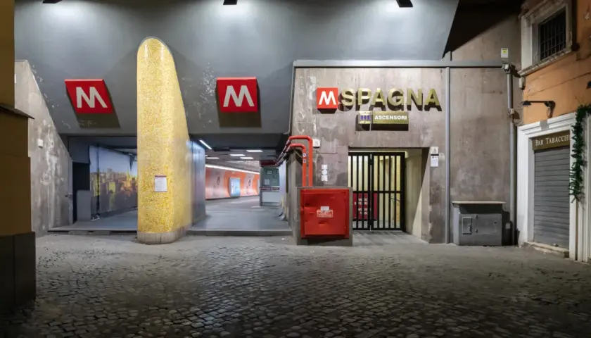 Ingresso della stazione metro Spagna a Roma, con insegna luminosa e pavimentazione in sampietrini.