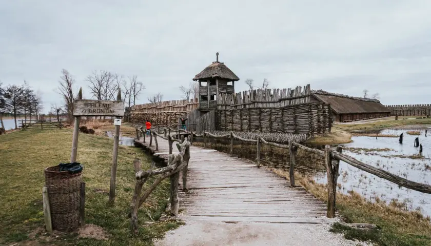 Drewniany most prowadzi do grodu z wieżą strażniczą, odtworzonego na szlaku piastowskim.