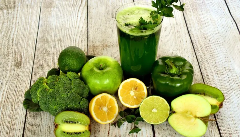 Zielony koktajl i świeże warzywa oraz owoce: brokuły, jabłka, kiwi, cytryny, limonka, papryka. Idealne składniki, by dowiedzieć się, jak oczyścić jelita.