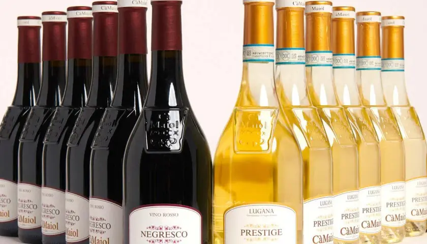 Bottiglie di vino rosso e bianco Cà Maiol Sirmione, con etichette che riportano "Negresco" e "Prestige".