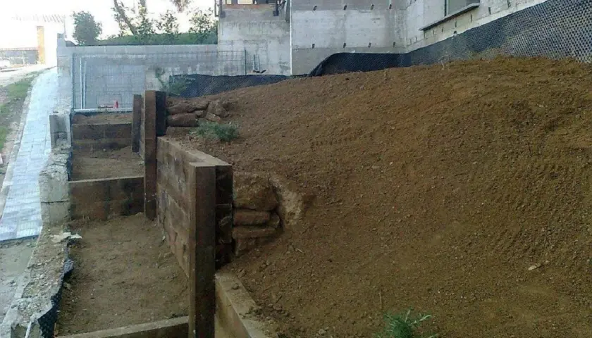 Costruzione di terrazzamenti con travi di legno per livellare pavimento in pendenza.