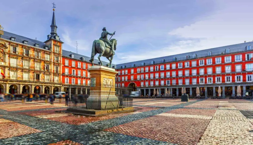 Plaza Mayor de Madrid, con estatua ecuestre y edificios rojos. Imagina llegar en tren santiago madrid y ver esta maravilla.