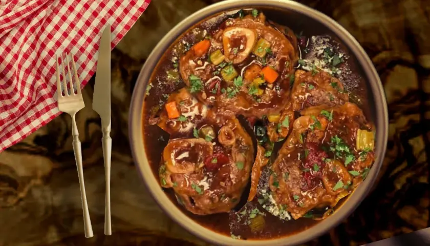 Un plat d'osso bucco de veau traditionnel, mijoté dans une sauce riche, garni de persil frais et de légumes. Servi avec une serviette à carreaux rouges et blancs et des couverts.