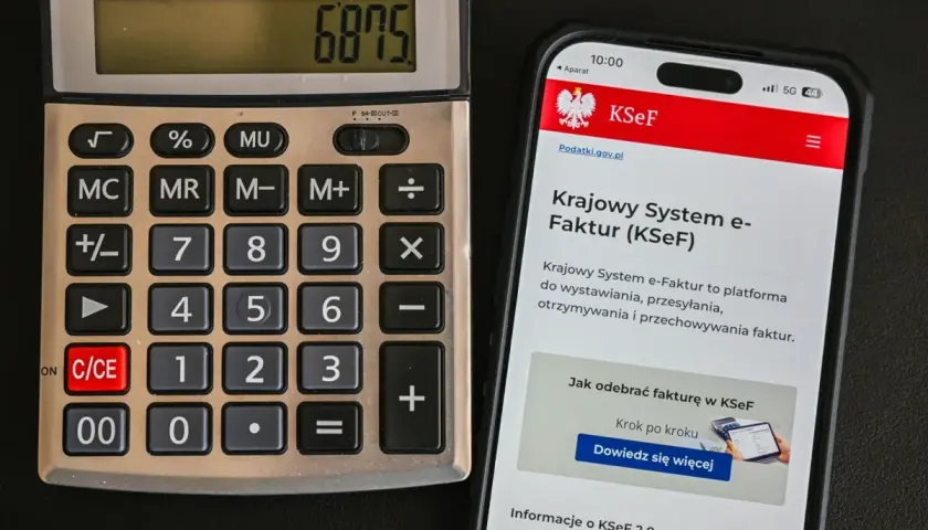 Kalkulator i smartfon z ekranem wyświetlającym Krajowy System e-Faktur (KSeF).