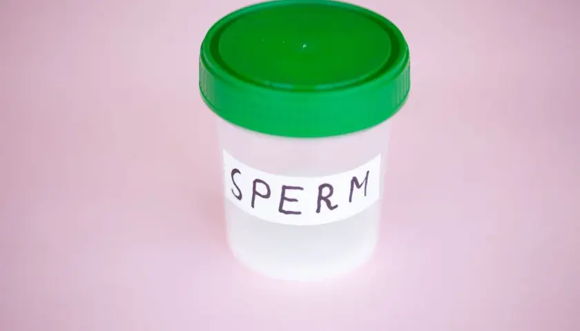 Contenitore con tappo verde, etichetta "SPERM". Potrebbe rappresentare un campione per analisi, legato a un'eiaculazione senza orgasmo.