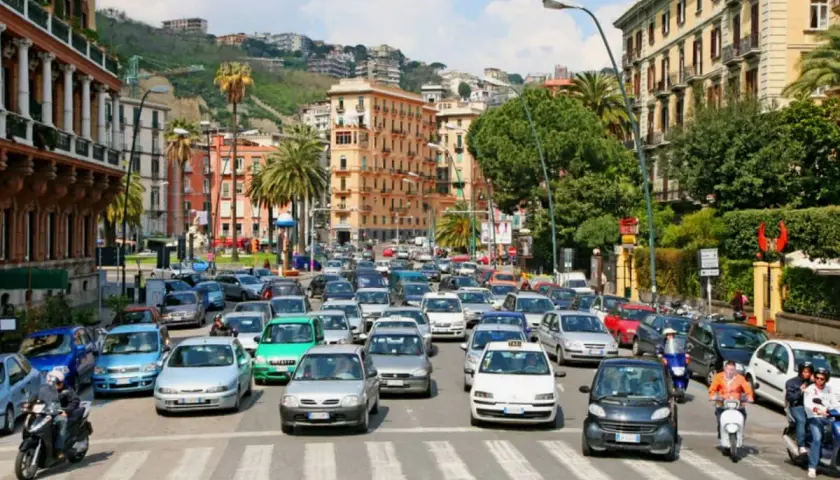 Busy street scene with cars and scooters, a typical day driving in Naples, Italy.