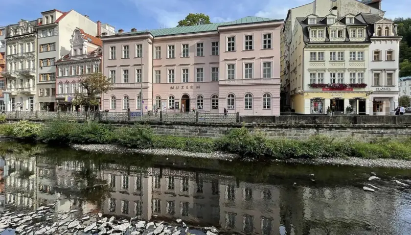 Nad rzeką w Karlowych Warach odbijają się w wodzie zabytkowe kamienice i budynek muzeum.