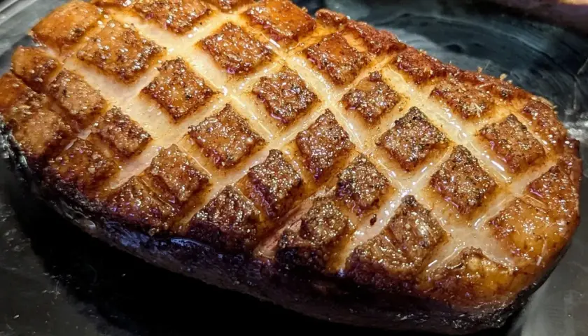 Magret de canard au four, la peau grillée en losanges, prête à être dégustée.