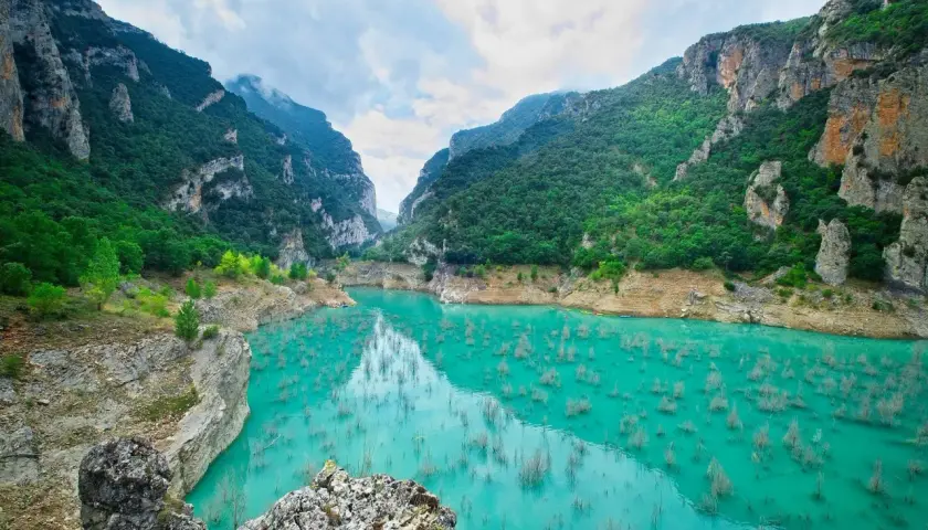 Impresionante cañón con agua turquesa y vegetación exuberante, ideal para rutas senderismo Catalunya.