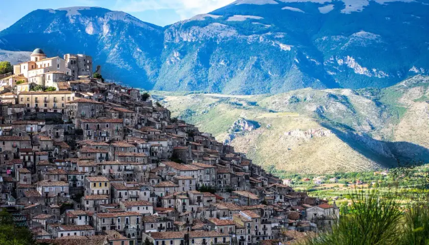 A picturesque village cascades down a mountainside, a perfect example of where to visit in Calabria for stunning views and historic charm.