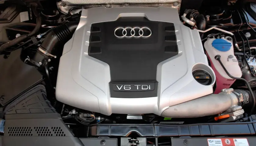 Silnik V6 TDI Audi, gotowy do pracy. Potężna jednostka napędowa z charakterystycznym logo czterech pierścieni.