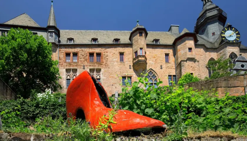 Ein riesiger roter Schuh vor dem Marburger Schloss – ein ungewöhnlicher Anblick, der zeigt, was man in Marburg machen kann: Kunst entdecken!