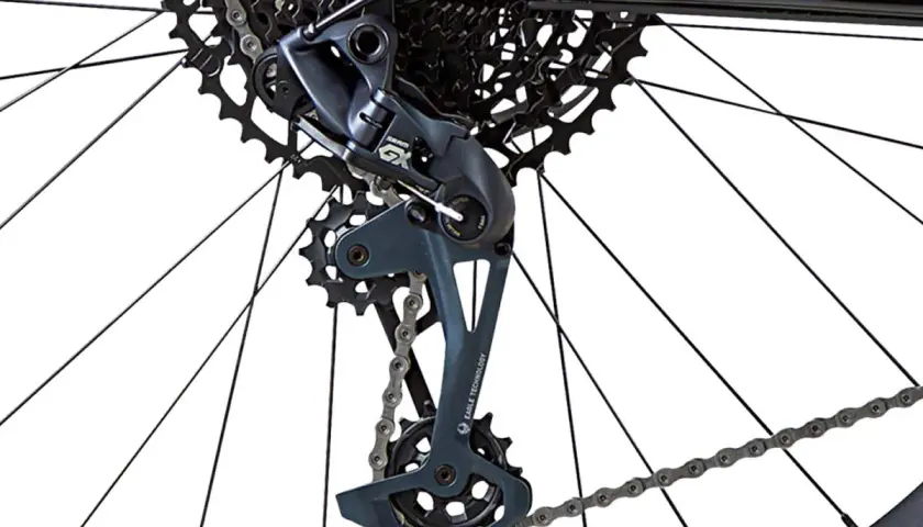 Close-up of a bicycle's rear derailleur with a bent derailleur hanger, showing the cassette and chain.
