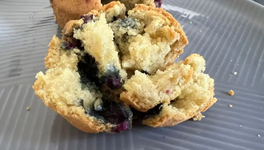 Muffin ai mirtilli appena sfornati nella friggitrice ad aria, con interno soffice e mirtilli succosi.