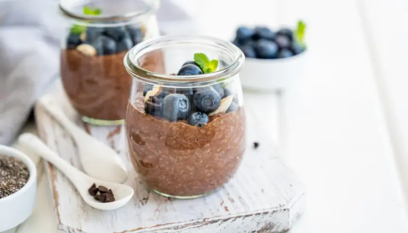 Czekoladowy pudding chia z jagodami i miętą w słoiku.
