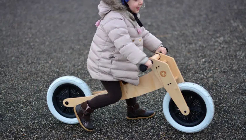 Dziecko na rowerku biegowym, ćwiczy motorykę. To świetny sposób na naukę równowagi i koordynacji.