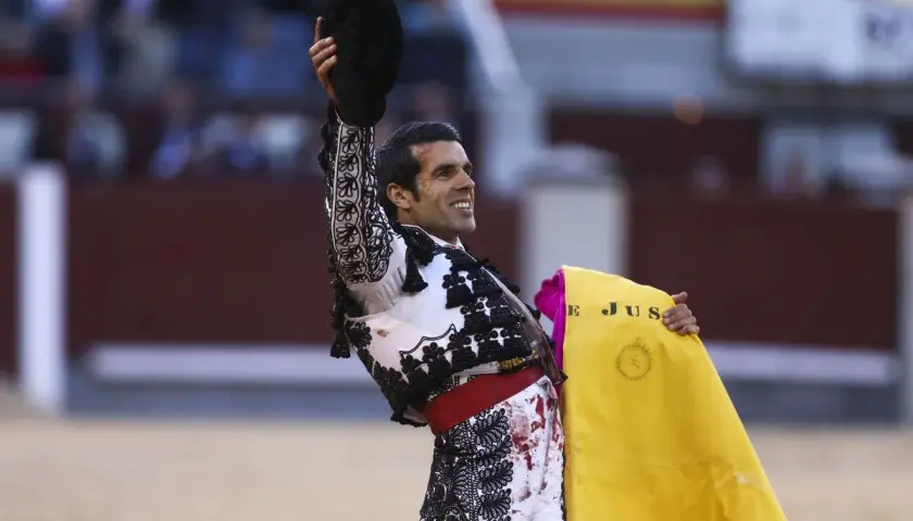 Un torero sonriente levanta su montera, con la muleta amarilla en la mano. Las caras de toreros son un reflejo de pasión y valentía.